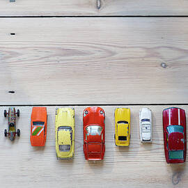 Toy Cars Lined Up In A Row On Floor by Dougal Waters