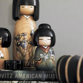 Various, Painted Wooden Kokeshi Dolls On Stacked Books by Stefan Thurmann