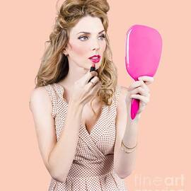 Woman applying lip makeup with cosmetics mirror by Jorgo Photography