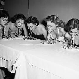 Women In A Spaghetti Eating Contest by Bettmann