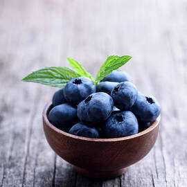 Blueberries  in wooden bowl close up by Jelena Jovanovic