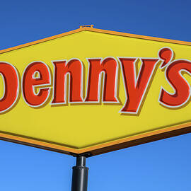 Denny's restaurant sign and logo against blue sky by Miroslav Liska
