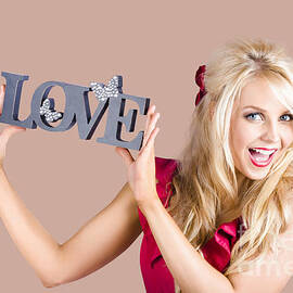 Fun blonde woman with love word sign by Jorgo Photography