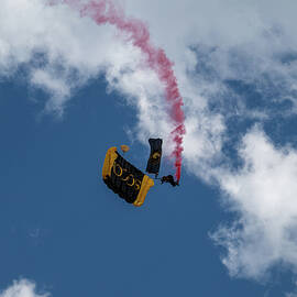 Golden Knights Skydiver with Red Smoke Against Blue Sky by Dave Koch by Dave Koch - Aircraft Photography