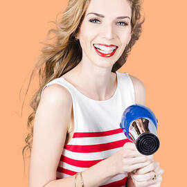 Happy female hairdresser holding hairdryer by Jorgo Photography
