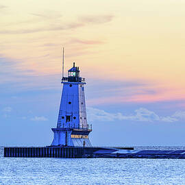 Lighthouse at Sunset Over Calm Waters by Michael Collins