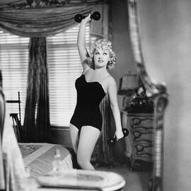 Mae West Lifting Barbell Bedroom Workout Swimsuit Leggy Elegant Classic Vintage Candid Exercise 1930 by Silver Screen