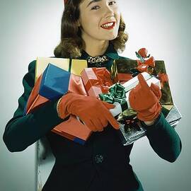 Model Wearing Christmas Hat and Holding Gifts by John Rawlings