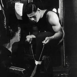 Portrait of Boxer Joe Louis Lacing His Boots by Lusha Nelson
