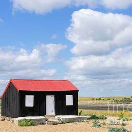 Red Roofed Hut, blue sky and clouds Rye Harbour Nature Reserve, Rye, East Sussex, England UK by Neale And Judith Clark