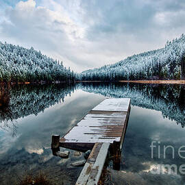 Snow-Covered Pier on Tranquil Lake by Thomas Nay