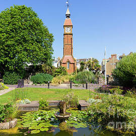 Victorian Memorial clock and lily pond with flower beds Jubilee gardens, Seaton, Devon, England, UK by Neale And Judith Clark
