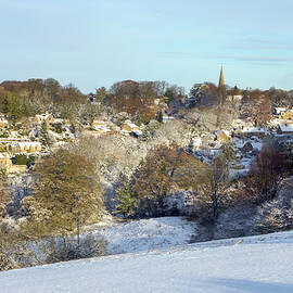 Winter sunshine on the picturesque village of Bisley under a bla by Seeables Visual Arts