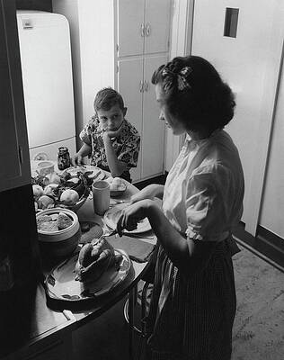 Teen Wall Art featuring the photograph A Boy Watching His Mother Prepare Dinner by Luis Lemus