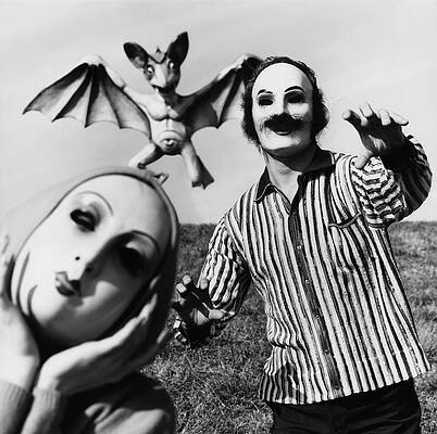 Bat Wall Art featuring the photograph A Man And Woman Wearing Masks With A Bat Flying by Chadwick Hall