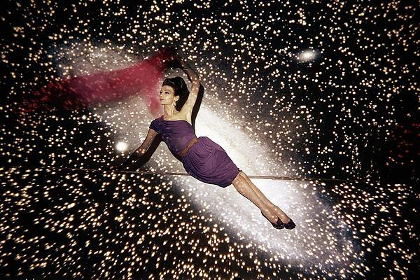 Wall Art featuring the photograph A Model Against A Galaxy Backdrop by John Rawlings