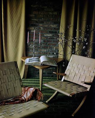 Candle Wall Art featuring the photograph An Armchair Beside A Table And An Old Book by Horst P. Horst