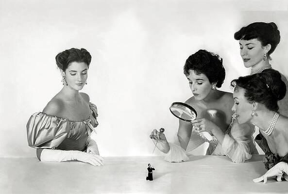 Elegant Women Examining Tiny Figure Photograph