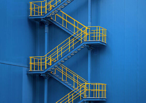 Wall Art featuring the photograph Yellow Metal Staircase Against A Blue by Ozgur Donmaz