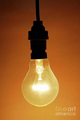 Glowing Light Bulb Against Orange Background Wall Art