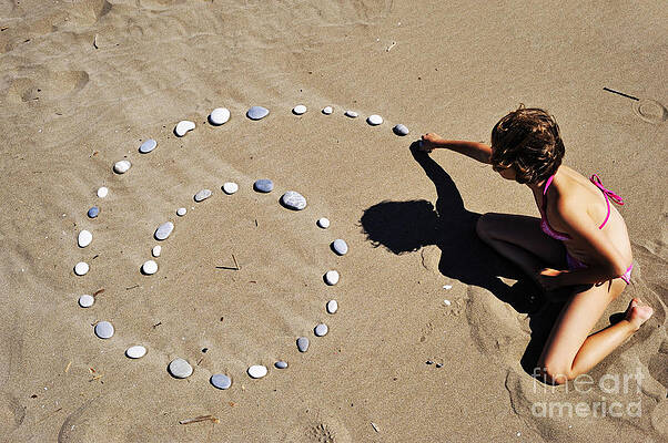 Beach Wall Art featuring the photograph Girl On Beach Displaying Pebbles In Spiral Shape by Sami Sarkis Photography
