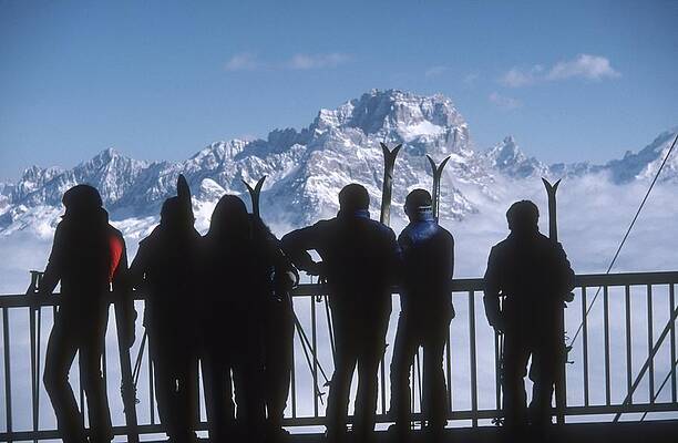 Skiers Admiring Mountain Peaks Wall Art