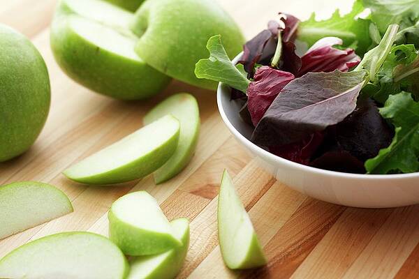 A Bowl Of Mixed Greens With Sliced Green Apple Print