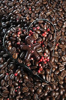 A Chocolate Figure On Top Of Coffee Beans With Red Peppercorns In A Heart-shaped Cutter Print
