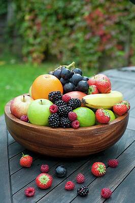 A Large Wooden Bowl Filled With Fresh Fruit And Berries Print