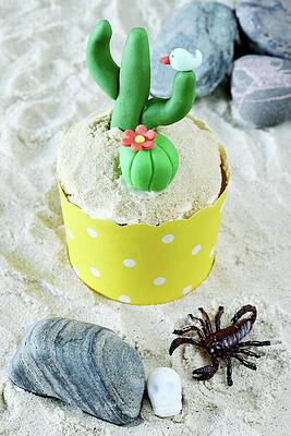 A Lemon Cupcake Decorated With A Cactus Print