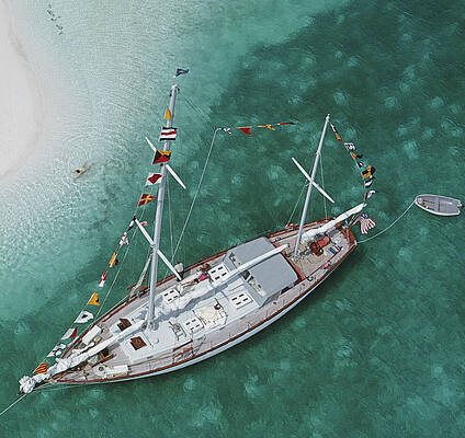 Sailing Ship Anchored Near Pristine Beach Wall Art