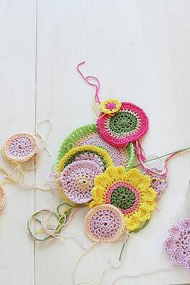 Crocheted Coasters Of Various Colours On White Surface Print