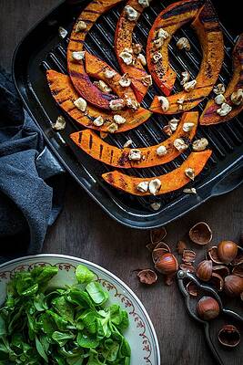 Grilled Pumpkin Strips With Hazelnuts In A Roasting Tin With A Side Of Lambs Lettuce Print