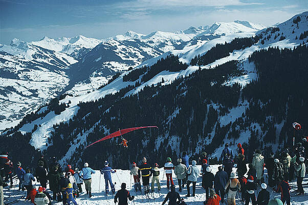 Crowd Watching Hang Glider Over Snowy Mountains Wall Art
