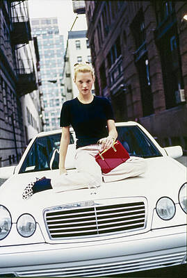 Person Sitting on a White Car Photograph