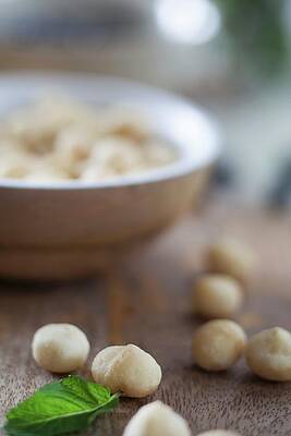Macadamia Nuts In And In Front Of A Wooden Bowl Print