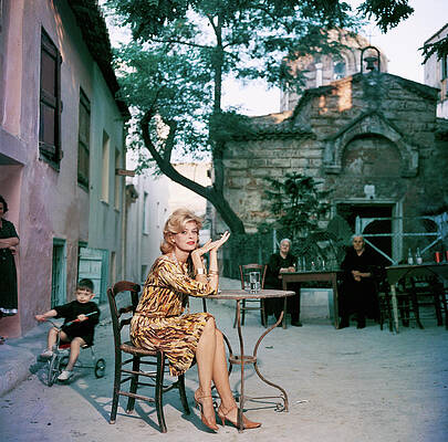 Woman in Vibrant Dress Sitting Outdoors Wall Art
