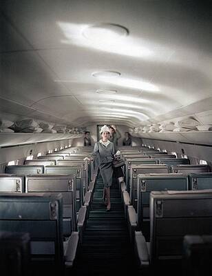 Wall Art featuring the photograph Model Walking Down An Airplane Aisle by John Rawlings