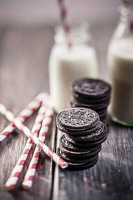 Stacks Of Oreo Cookies With Milk Bottles And Drinking Straws On A Wooden Slab Print