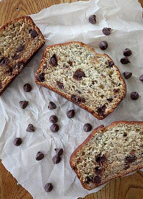 Three Slices Of Banana Bread With Chocolate Chips On A Piece Of Parchment Paper Print