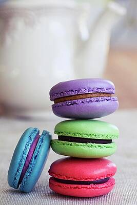 Various Different Coloured Macaroons Stacked In Front Of A Teapot Print