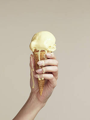 Wall Art featuring the photograph Woman Holding Melting Ice Cream Cone by Walker And Walker
