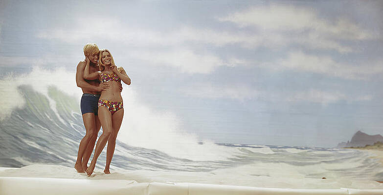 Wall Art featuring the photograph Young Couple Standing On Beach, Smiling by Tom Kelley Archive