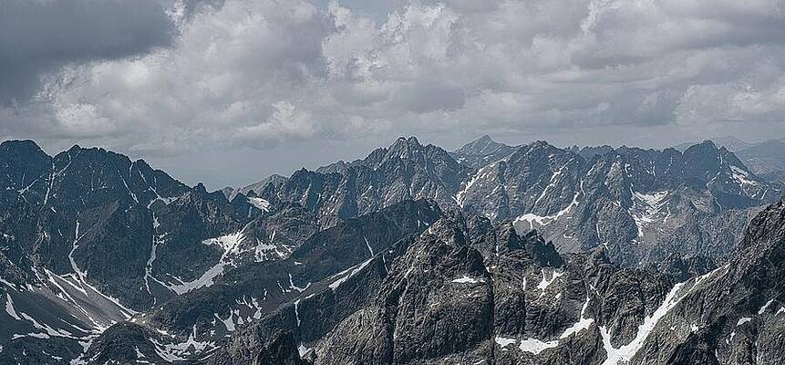 Majestic Mountain Range Under Cloudy Sky Photograph