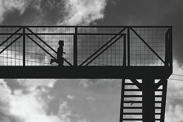 Silhouette of Runner on Bridge Photograph