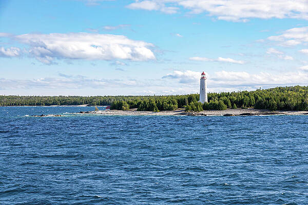 Lighthouse on Rocky Shoreline Photograph