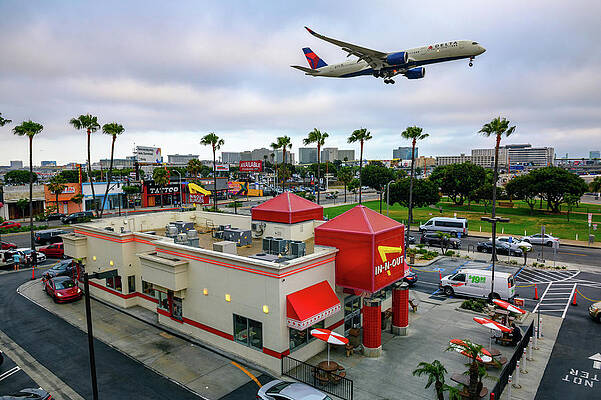 Travel Wall Art featuring the photograph Delta Airlines Plane Flies Above In-N-Out Burger Restaurant While Landing At The Los Angeles International Airport LAX by Miroslav Liska
