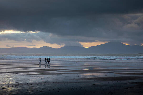People Strolling on a Moody Beach Photograph