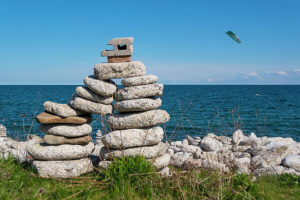 Summer Wall Art featuring the photograph Large Inukshuk By A Lake With Parasailor by John Twynam