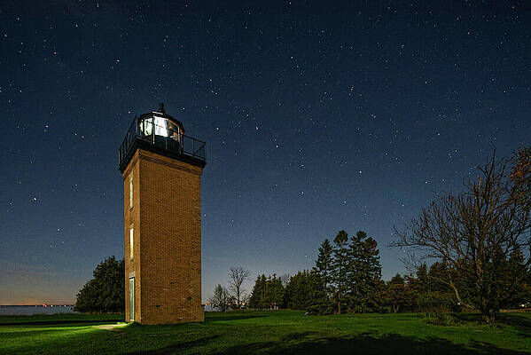 Lighthouse Under a Starry Night Sky Photograph